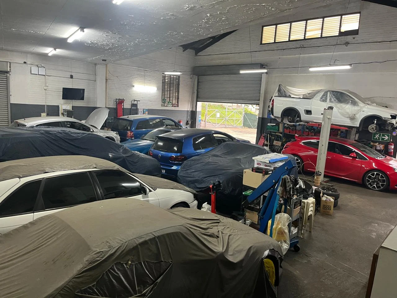 Technician running AC diagnostics on a BMW M3 outside the Astral Motors workshop